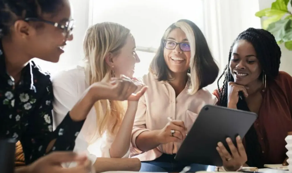 Grupo de quatro mulheres conversando descontraidamente